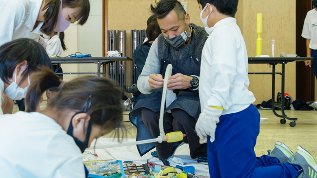 「世界津波の日」に漂着ゴミで日本列島を再現した共創アートを徳島県美波町へ寄贈のサブ画像6_さまざまゴミから思い思いの素材を集める生徒と淀川テクニック