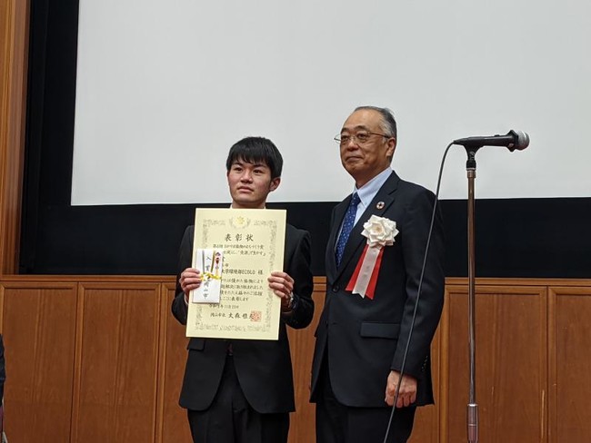【岡山大学】環境部ECOLOによる「リサイクル市」の活動が「おかやま協働のまちづくり賞」で入賞！のサブ画像2_環境部ECOLOを代表して串田光寿さん（左）が表彰式に参加