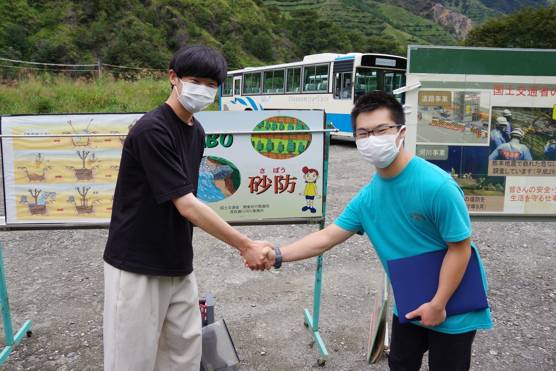 日光市足尾町の渡良瀬川の最上流の砂防の現場で、「大学生と楽しく学びながら植樹に励む高校生たち」に、宇都宮大学地域デザイン科学部が「社会貢献賞」をお贈りしました。のサブ画像2_表彰する側とされる側、共に社会や地域に貢献する喜びで心が重なり合います。地域デザイン科学部コミュニティデザイン学科の学生（写真左）から特別支援学校の1年生の代表者（写真右）へ。（2022年9月9日の植樹活動を終えた後）