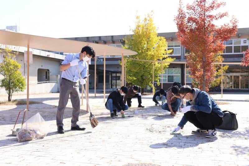 【岡山大学】第1回おそうじ桃太郎プロジェクト「みんなで草退治をしよう！」を実施のサブ画像3_学生・教職員が協力して草刈りを行う様子