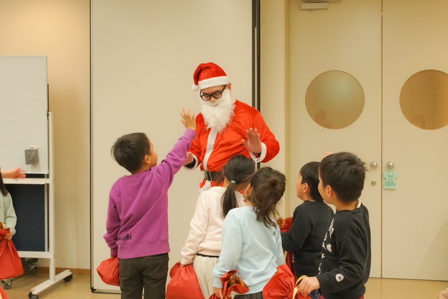 【TCBクリスマスプロジェクト】TCB東京中央美容外科のドクターが、児童養護施設の子どもたちにギフトを届けるサンタクロースに変身。未来ある子どもたちに笑顔をのサブ画像3_クリスマスギフトを手渡しする様子